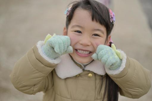 A girl wearing a coat and gloves and laughing vigorously, JPG