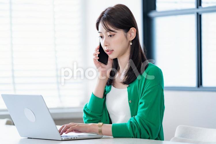 仕事をするカーディガンを着た女性 パソコン,pc,ミーティングの写真素材