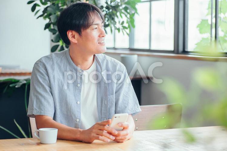 家でスマホを使う男性（アプリ） スマホ,男性,スマートフォンの写真素材