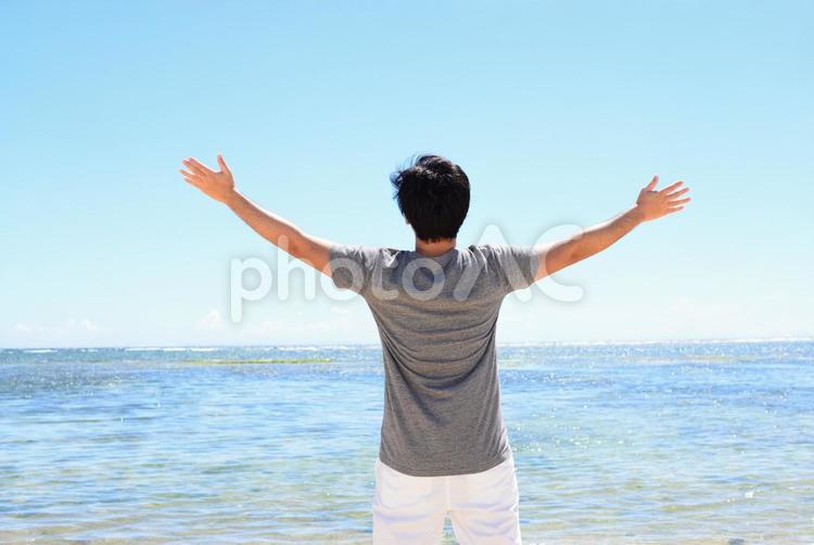 海辺でくつろぐ男性 海,男性,沖縄の写真素材