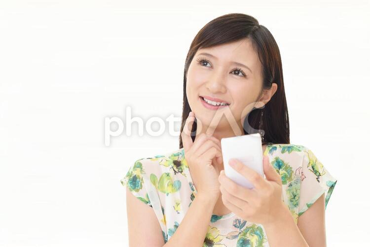 スマートフォンを持つ笑顔の女性 女性,スマートフォン,女の写真素材