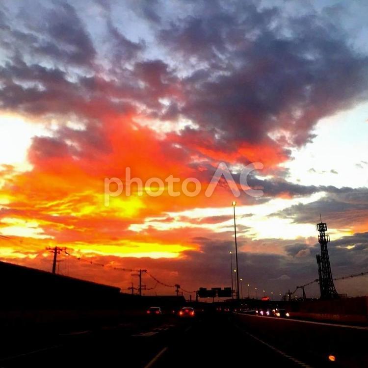 黒い雲の立ち込める夕陽の風景、湾岸線から 夕焼け,夕日,夕景の写真素材