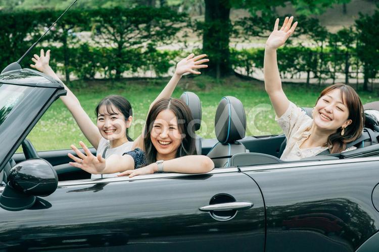 ドライブする女性たち（手を振る） 旅行,車,友達の写真素材
