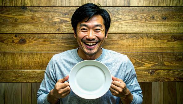 食後、空になったお皿を前に笑顔の男性 食後、空になったお皿を前に笑顔の男性の写真