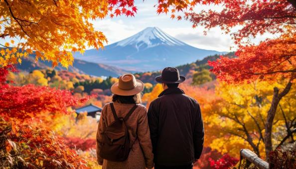 美しい紅葉を眺める夫婦の後ろ姿の写真