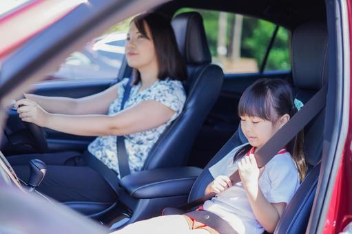 お母さんと車に乗る小さな女の子 お母さんと車に乗る小さな女の子の写真