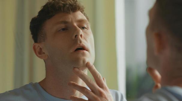 洗面所の鏡に映った顎を触っている男性 男性,外国人,欧米人の写真素材