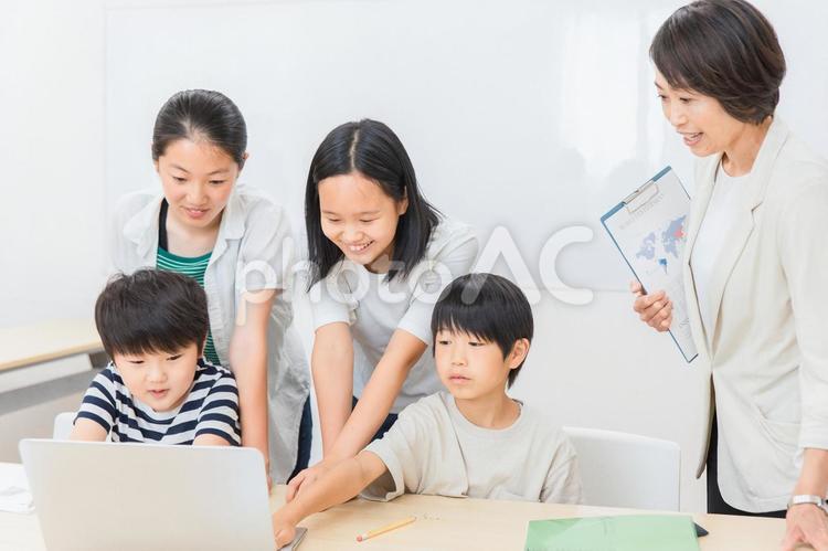 パソコンで授業を受ける小学生の子供と先生 塾,グループワーク,英会話の写真素材