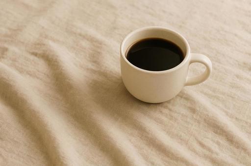 リネンの布の上にコーヒーカップ リネンの布の上にコーヒーカップの写真
