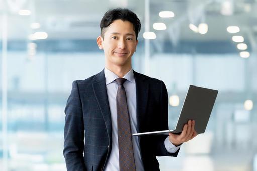 ノートパソコンを持つ男性ビジネスマン 男性,パソコン,ノートパソコンの写真素材