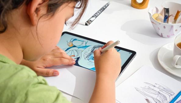 タブレットPCでイラストを描く小学生手元の写真