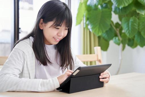 Junior high school girls looking at a tablet in the living room, JPG Junior high school girls looking at a tablet in the living room, JPG