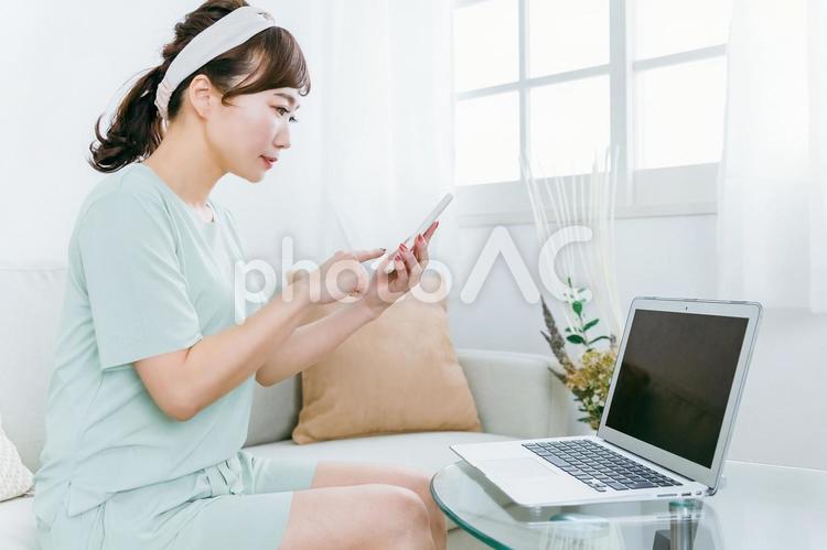 家でパソコンとスマホを使う日本人女性 スマホ,女性,パソコンの写真素材