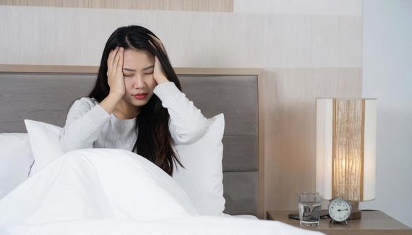 起床時に寝不足と疲労と体調不良の女性 起床時に寝不足と疲労と体調不良の女性の写真