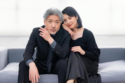 ソファに座る落ち着いた大人の男女 熟年,カップル,ミドルの写真素材