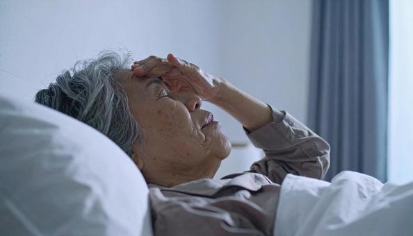 夜、眠れずに悩むシニア女性の横顔 夜、眠れずに悩むシニア女性の横顔の写真