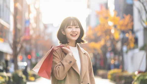 買物袋を持って笑顔でショッピングする女性 買物袋を持って笑顔でショッピングする女性の写真
