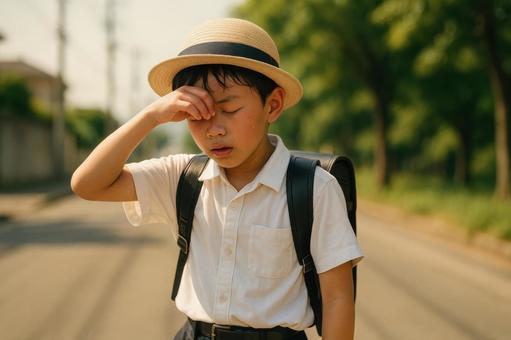 暑さでぐったりする小学生の下校風景 暑さでぐったりする小学生の下校風景の写真