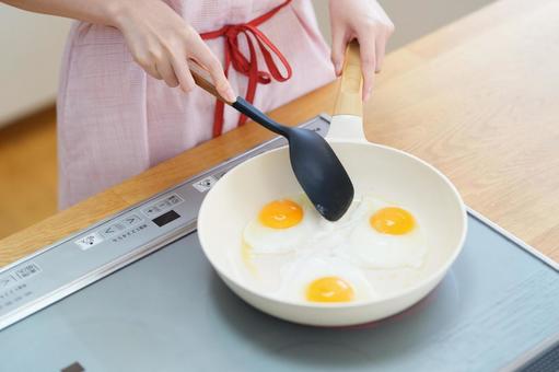 目玉焼きを作っている手元 目玉焼き,料理,フライパンの写真素材