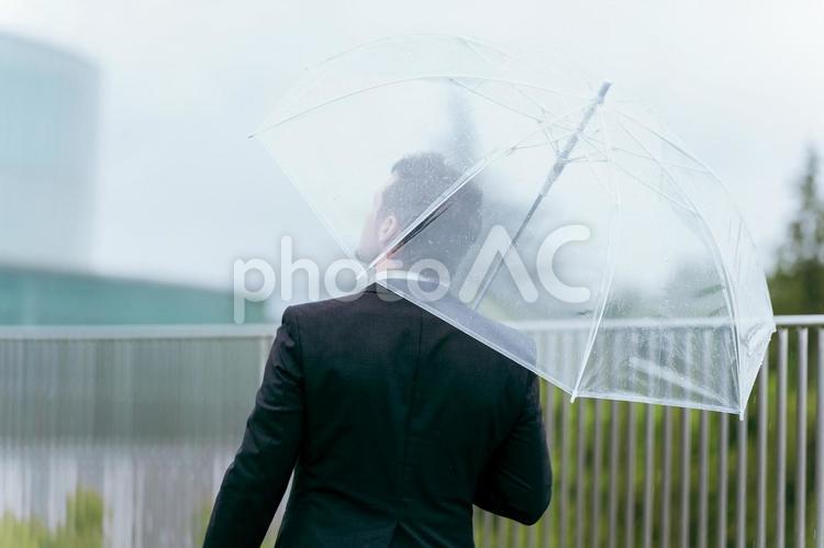梅雨・雨の日に傘をさす外国人ビジネスマン 傘,雨傘,雨の写真素材