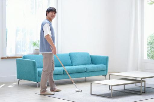 カメラ目線でカーペットクリナーを持つ男性 男性,カーペットクリーナー,振り向くの写真素材