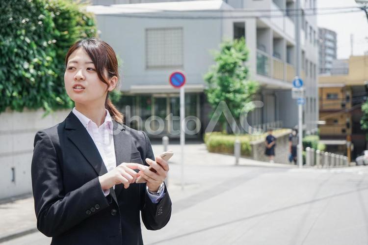 スマホで場所を探す若いビジネスウーマン 携帯電話,ガイド,方角の写真素材