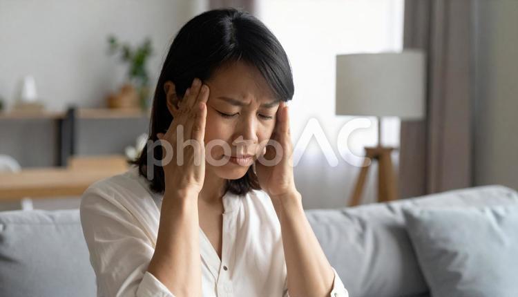 頭が痛くて思わずおさえる日本女性 偏頭痛,痛み,睡眠不足の写真素材