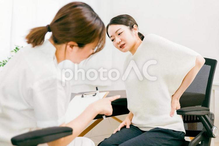 腰痛で悩む女性を診察する医師（整体） 腰痛,整体,腰の写真素材