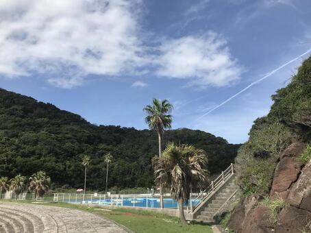 飛行機雲とヤシの木のあるプールサイド 鐘,青空,海の写真素材