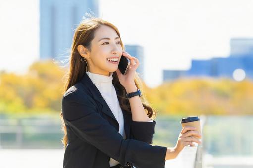 スマホで話す笑顔の女性・ビジネスウーマン 女性,スマホ,スマートフォンの写真素材
