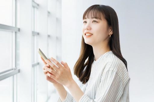 スマホを使う笑顔の女性・ビジネスウーマン スマホを使う笑顔の女性・ビジネスウーマン 女性,スマホ,スマートフォンの写真素材