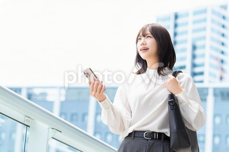 屋外でスマホを持つ女性・ビジネスウーマン 女性,スマホ,スマートフォンの写真素材