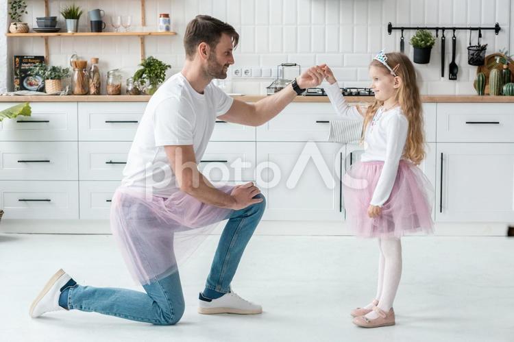 女の子の手を持つ横向きの父 女の子,父,片膝の写真素材