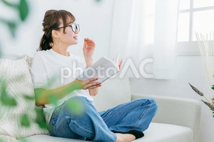 家のソファで読書するおしゃれな日本人女性 読書,本,読むの写真素材