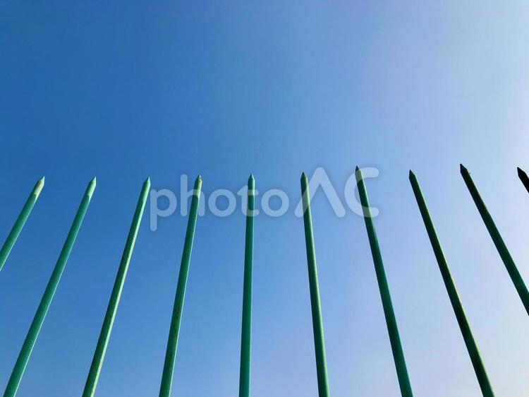 先端の尖った鉄柵と抜けるように青い空 鉄柵,フェンス,青空の写真素材