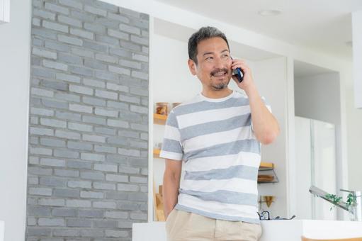 キッチンでスマホを使うミドルの男性 キッチンでスマホを使うミドルの男性 男性,スマホ,ミドルの写真素材