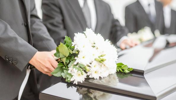 葬式でお棺に白い花束を入れる人の手もと 葬式でお棺に白い花束を入れる人の手もとの写真