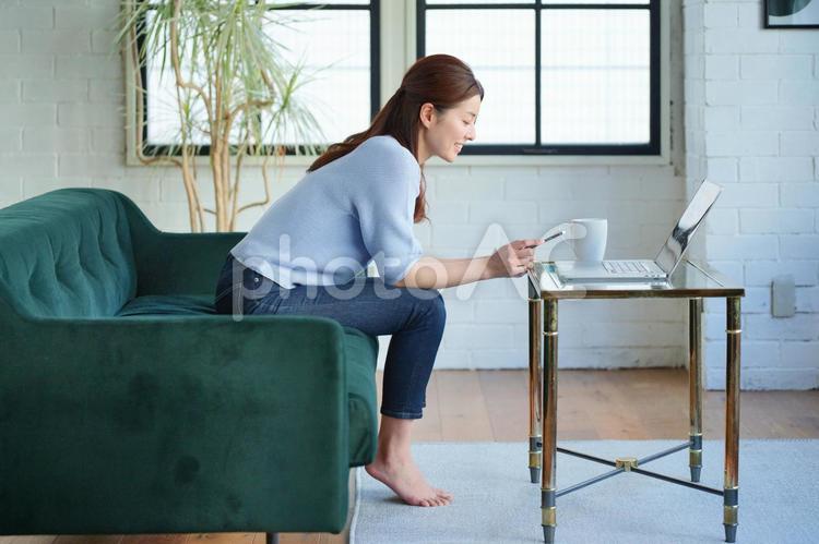 ソファーに座ってスマートフォンを使う女性 女性,日本人,1人の写真素材