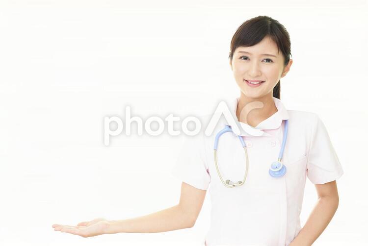 掌を見せる笑顔の看護師 女性,女,看護師の写真素材