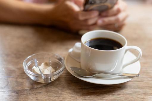 スマートフォン｜女性の手｜カフェコーヒー コーヒー,ブラックコーヒー,カフェの写真素材