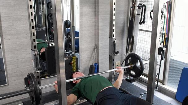 スポーツジムでベンチプレスをする若い男性 スポーツジムでベンチプレスをする若い男性 ベンチプレス,ジム,フィットネスの写真素材