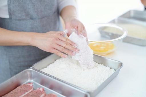 豚肉に小麦粉をつけている人の手 豚肉に小麦粉をつけている人の手 とんかつ,衣づけ,つけるの写真素材