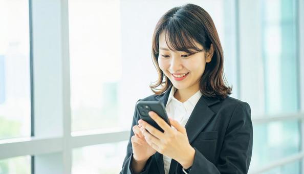 スマホを確認するビジネス女性 スマホを確認するビジネス女性の写真