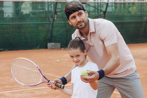 ラケットを持つ女の子とサポートする大人 親子,女の子,男性の写真素材