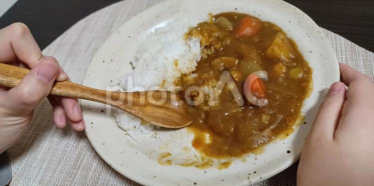 木のスプーンでカレーライスを食べる カレーライス,木のスプーン,手元の写真素材