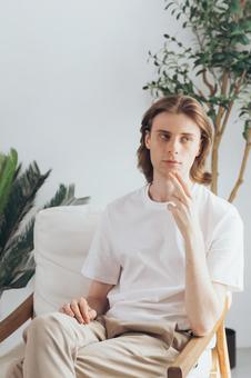 椅子に座る顎に手を当てている男性 男性,外国人,欧米人の写真素材