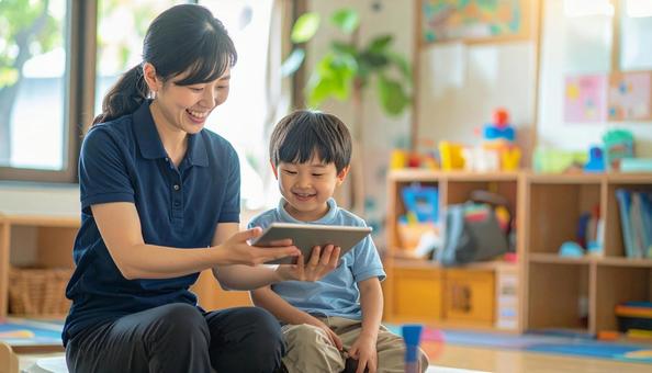 タブレットで遊ぶ保育士と子ども タブレットで遊ぶ保育士と子どもの写真