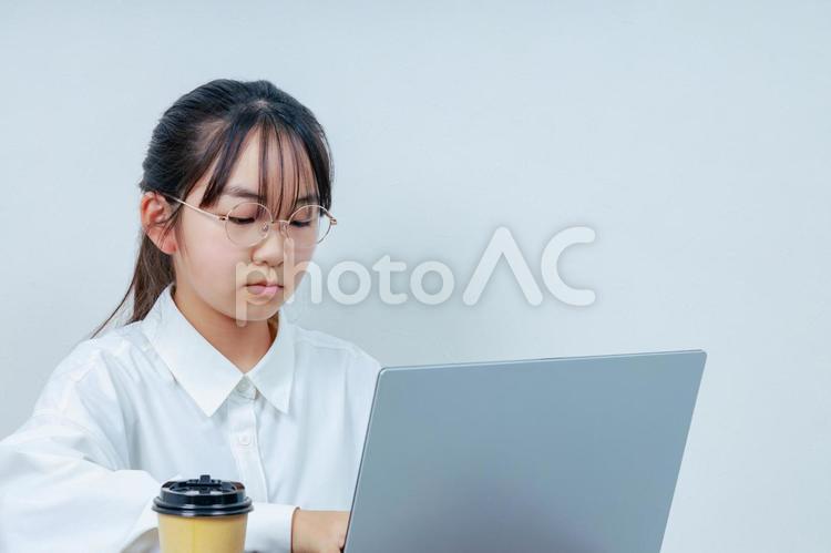 ノートPCを操作する眼鏡をかけた女の子 女性,小学生,少女の写真素材