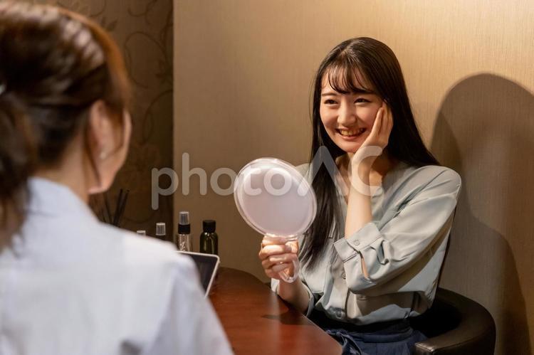 カウンセリングを受ける女性（鏡・ハリ） カウンセラー,ビューティーアドバイザー,肌診断の写真素材