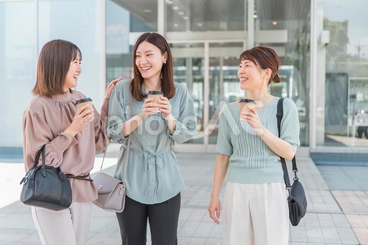 コーヒーを持ちながら話すアジア人女性 同僚,ビジネスウーマン,ビジネスの写真素材